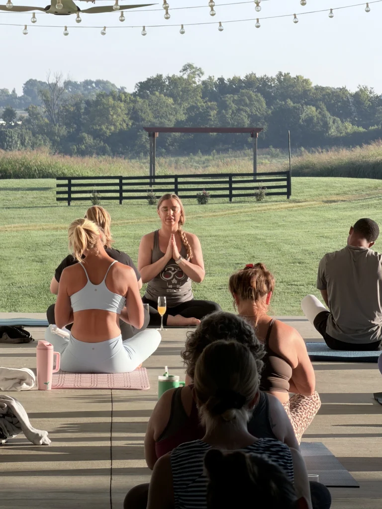 Ivy leading a class on a covered patio overlooking a field